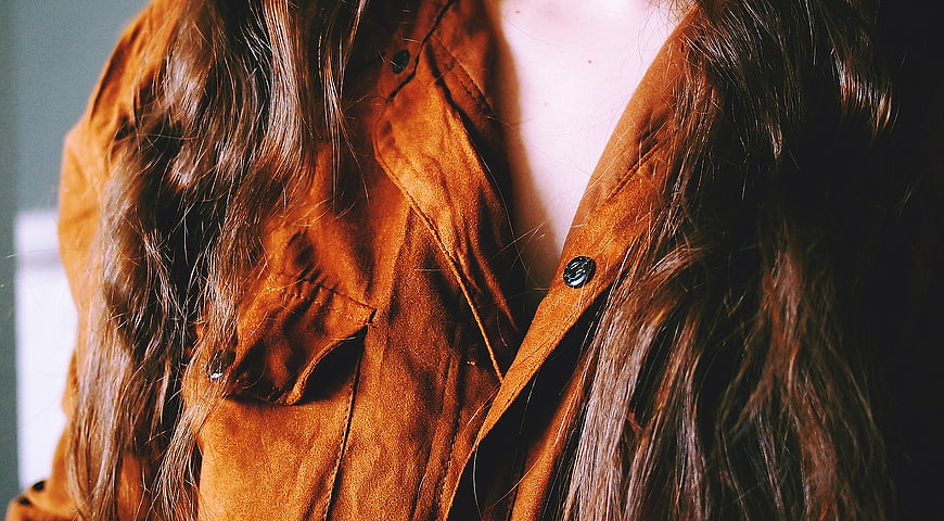 Close-up of woman in brown suede jacket with long hair