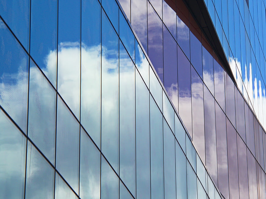 Modern Glass Building Facade with Sky Reflection