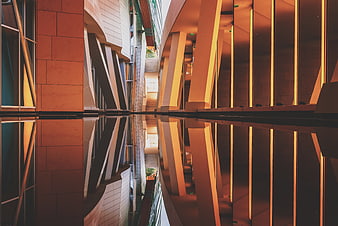 Modern architectural reflection in water with warm lighting