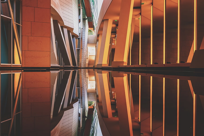 Modern architectural reflection in water with warm lighting