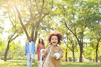 Happy African American Family Running in Sunny Park