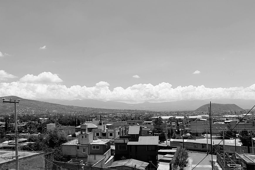 Black and white cityscape with mountains and clouds