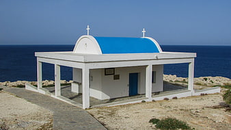 White Greek Orthodox Church with Blue Dome by the Sea
