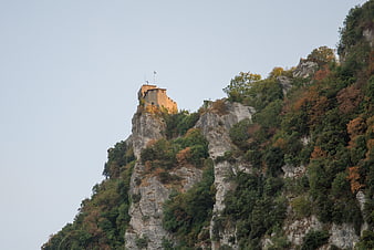 Medieval fortress perched on a rocky mountain peak in autumn