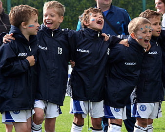 Young Boys Celebrating Joyfully In Football Team Uniforms