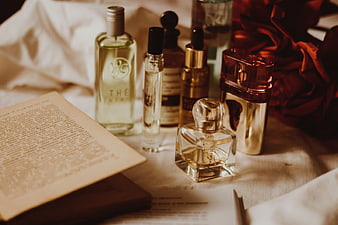 Vintage perfume bottles and open book on linen