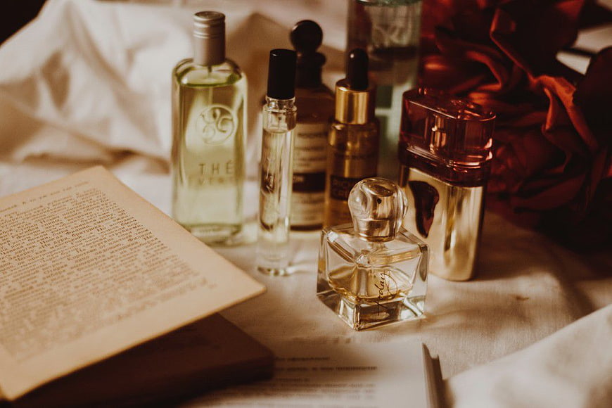 Vintage perfume bottles and open book on linen