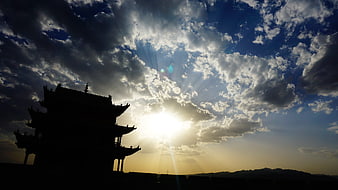 Silhouette of Jiayuguan Fort against dramatic sunset sky