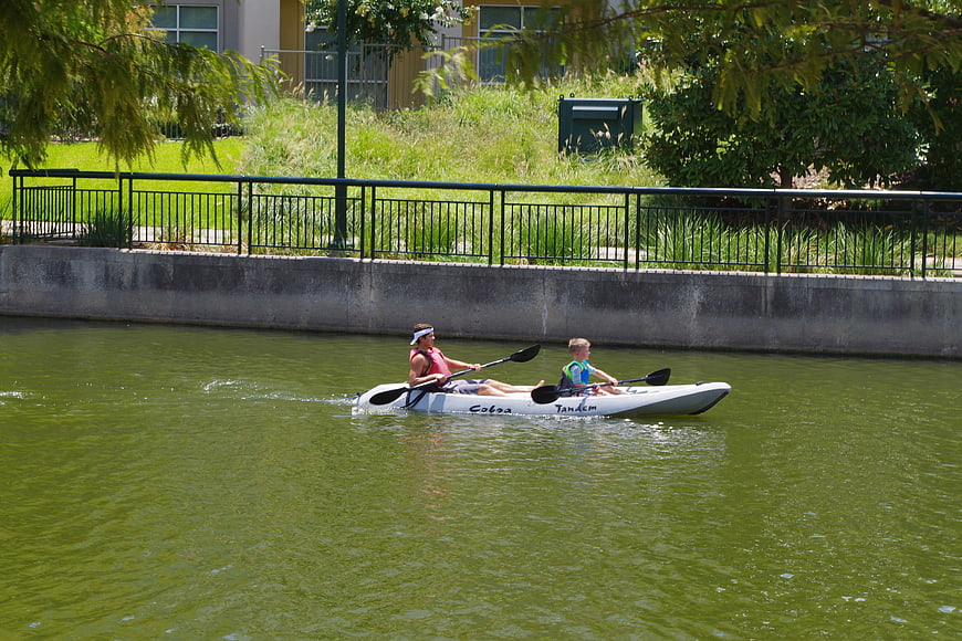 Father and Son Kayaking on a Green River