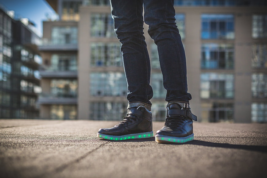 Person wearing LED light-up sneakers on city rooftop