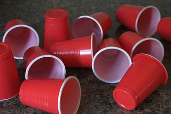 Scattered Red Plastic Cups On Dark Granite Surface
