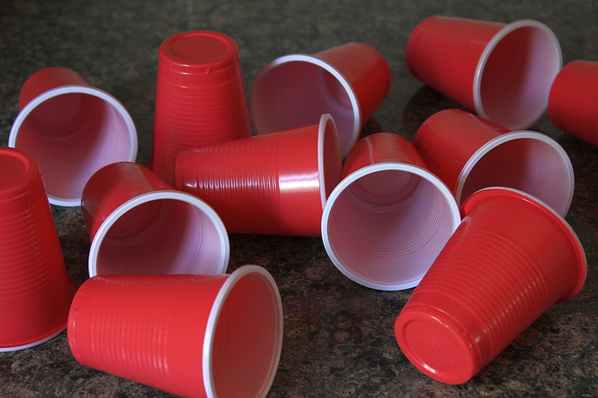 Scattered Red Plastic Cups On Dark Granite Surface