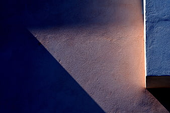 Abstract geometric shadow on textured wall with warm light