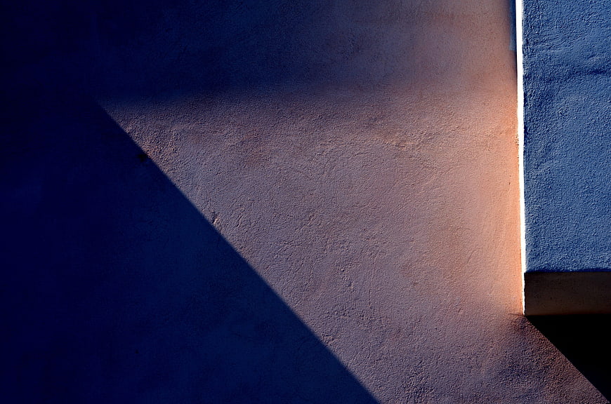 Abstract geometric shadow on textured wall with warm light