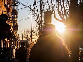 Silhouette of Woman Walking on City Street at Sunset