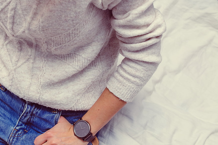 Close-up of woman wearing grey sweater and watch