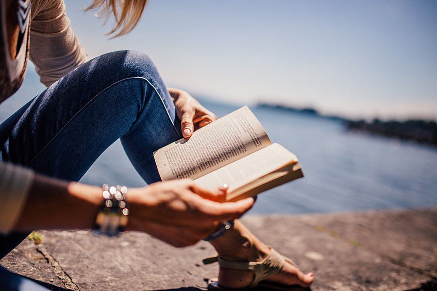 Woman Reading Book by the Sea