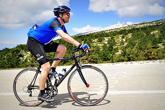 Male Cyclist Climbing Mountain Road in Blue Jersey