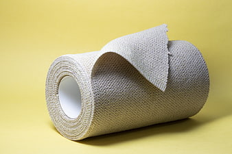 Roll of Medical Gauze Bandage on Yellow Background