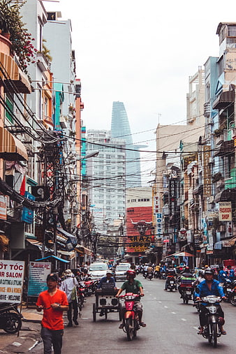 Busy Ho Chi Minh City Street with Motorbikes and Bitexco Tower