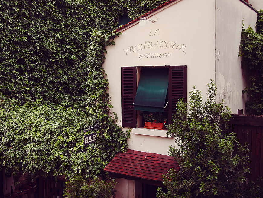 Charming French Restaurant Exterior with Ivy and Shutters