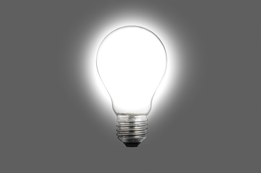 Glowing Light Bulb on Gray Background