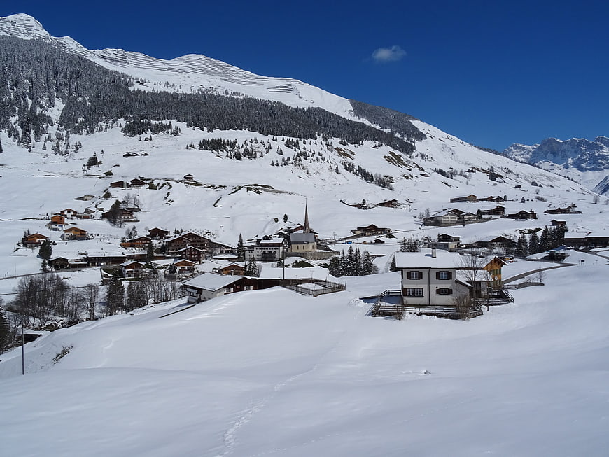 Snowy Alpine Village with Church and Mountains