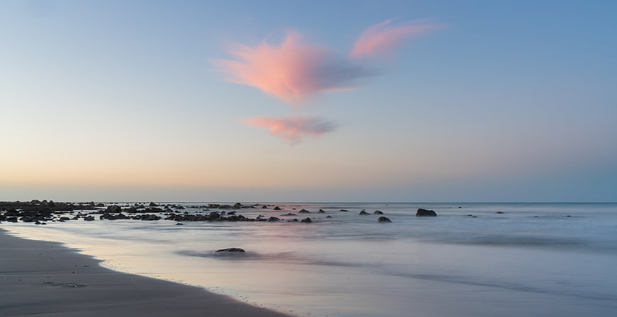 Serene Long Exposure Beach Sunset with Pink Clouds