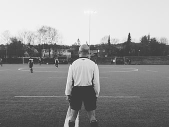Soccer Referee Standing on Pitch Watching Game