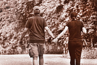 Senior couple holding hands walking away in sepia tone