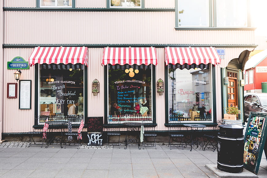 Charming Pink French Bistro Storefront with Red Striped Awnings