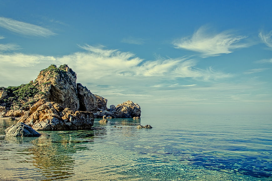 Rugged coastal cliffs meeting clear turquoise Mediterranean waters