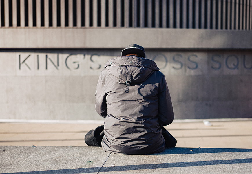 Man sitting alone on steps in King's Cross Square