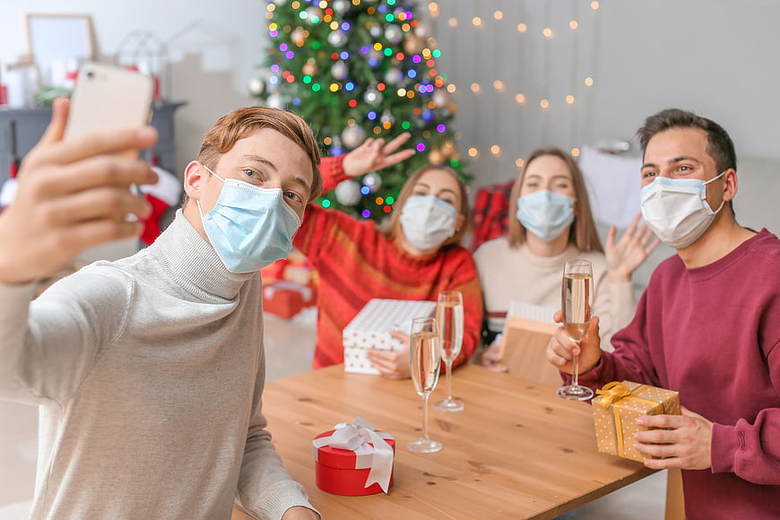Friends taking a selfie with face masks at a Christmas party