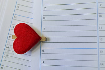Red felt heart bookmark on a monthly calendar page