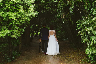 Bride and Groom Walking Away in Forest with Umbrella