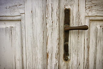 Close-up of weathered white wooden door with vintage handle
