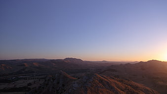 Golden Hour Sunset Over Rolling Hills and Mountain Ridge
