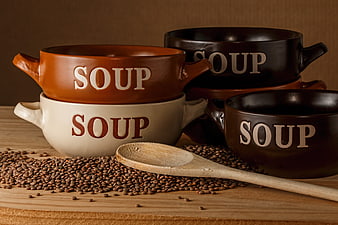 Stacked ceramic soup bowls with lentils and wooden spoon