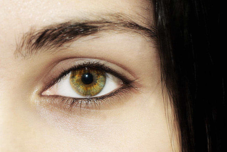 Close-up of a woman's hazel eye with detailed iris texture
