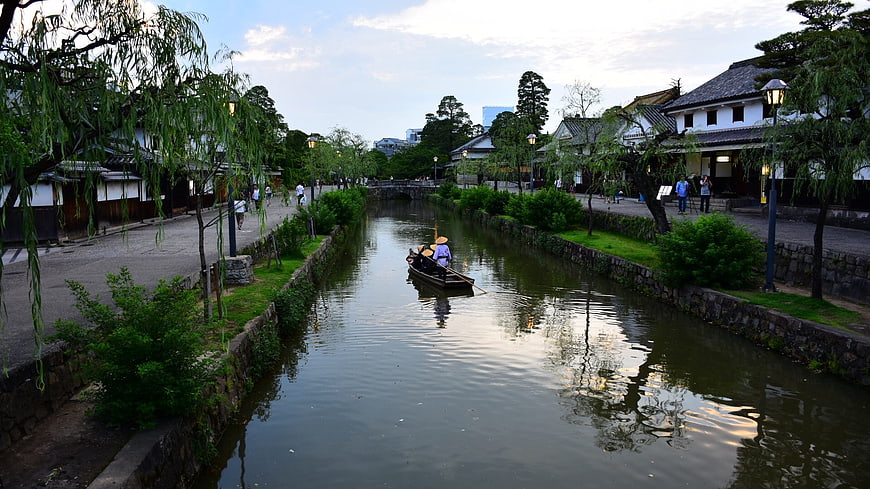 Traditional Japanese boat on canal with willow trees