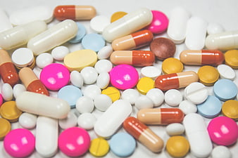 Colorful assortment of pills and capsules on white background