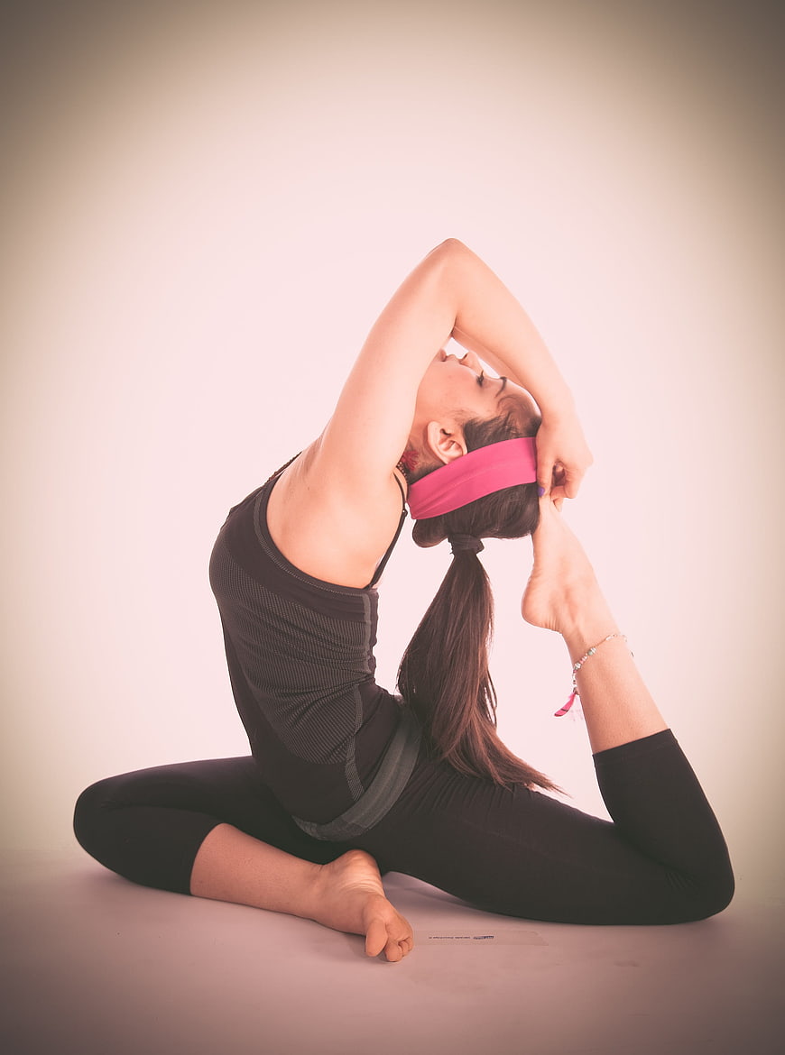Flexible Woman Performing Yoga Stretch in Studio