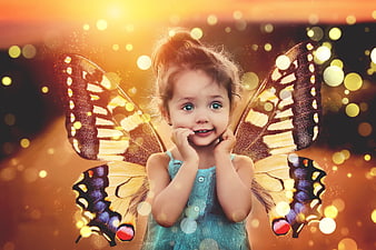 Cute little girl with magical butterfly wings and golden bokeh