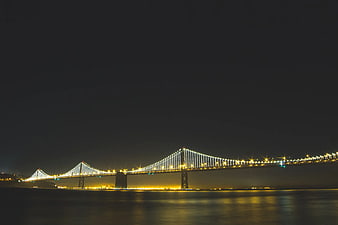 Istanbul Bosphorus Bridge illuminated at night with water reflections