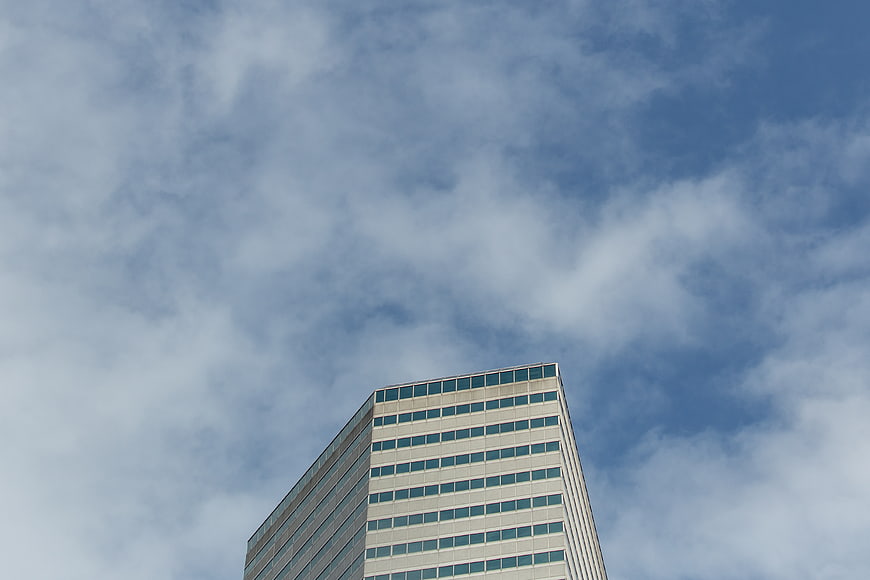 Low Angle View of Modern Skyscraper Against Cloudy Sky