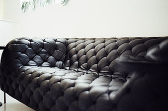 Close-up of black tufted leather sofa interior