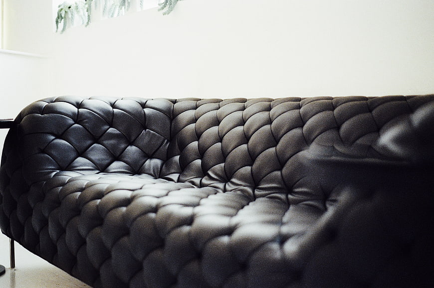 Close-up of black tufted leather sofa interior