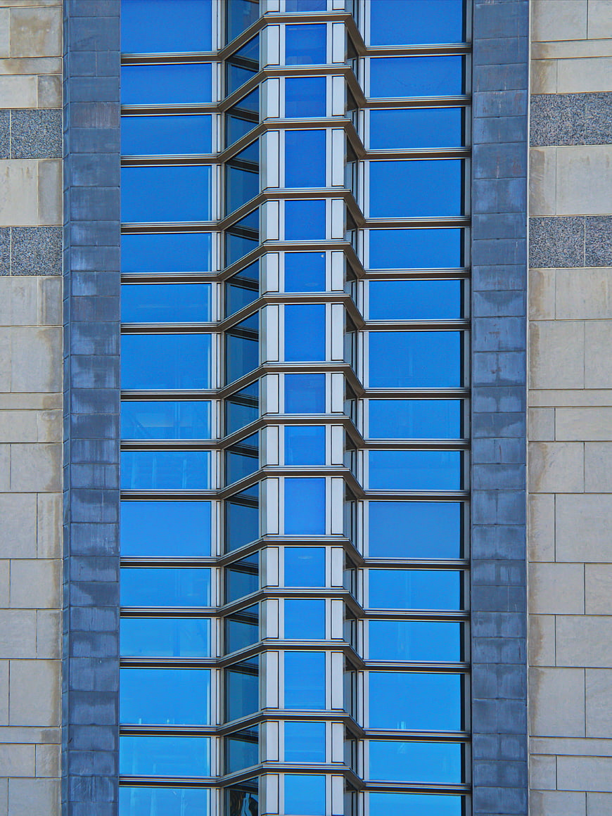 Modern Blue Glass Building Facade with Geometric Window Pattern