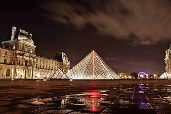 Illuminated Louvre Pyramid at Night with Wet Reflections